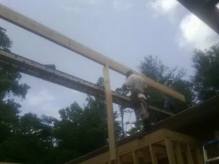 Carpenter setting a ridge beam over a new addition frame — Ice Dam Removal by Roofing Brothers in Ohiopyle