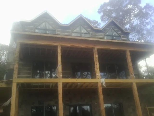 Dormers and porch framing on a large log home under construction — Roof Coating work by our crew in Ohiopyle