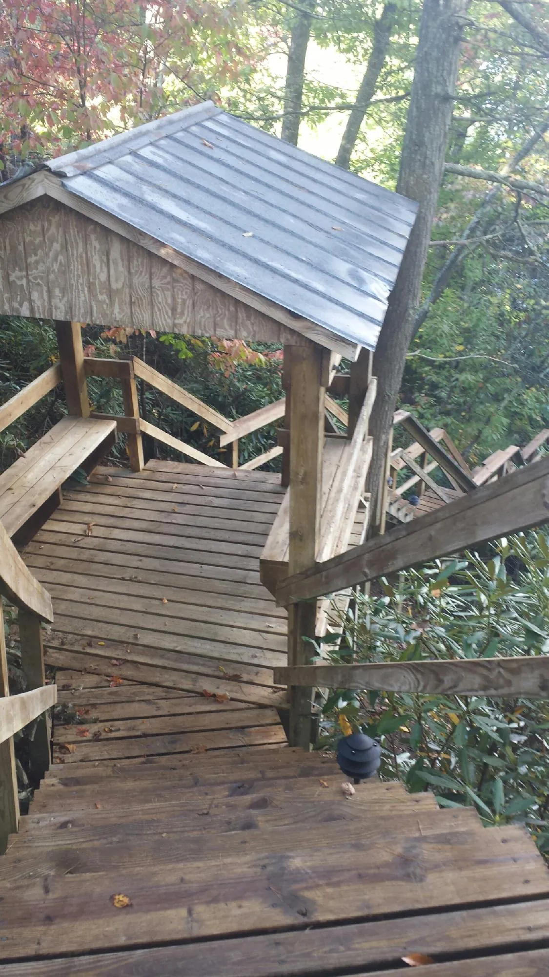 Metal roofed shelter over wooden steps on a wooded walkway — Skylight Repair & Installation work by our crew in Ohiopyle