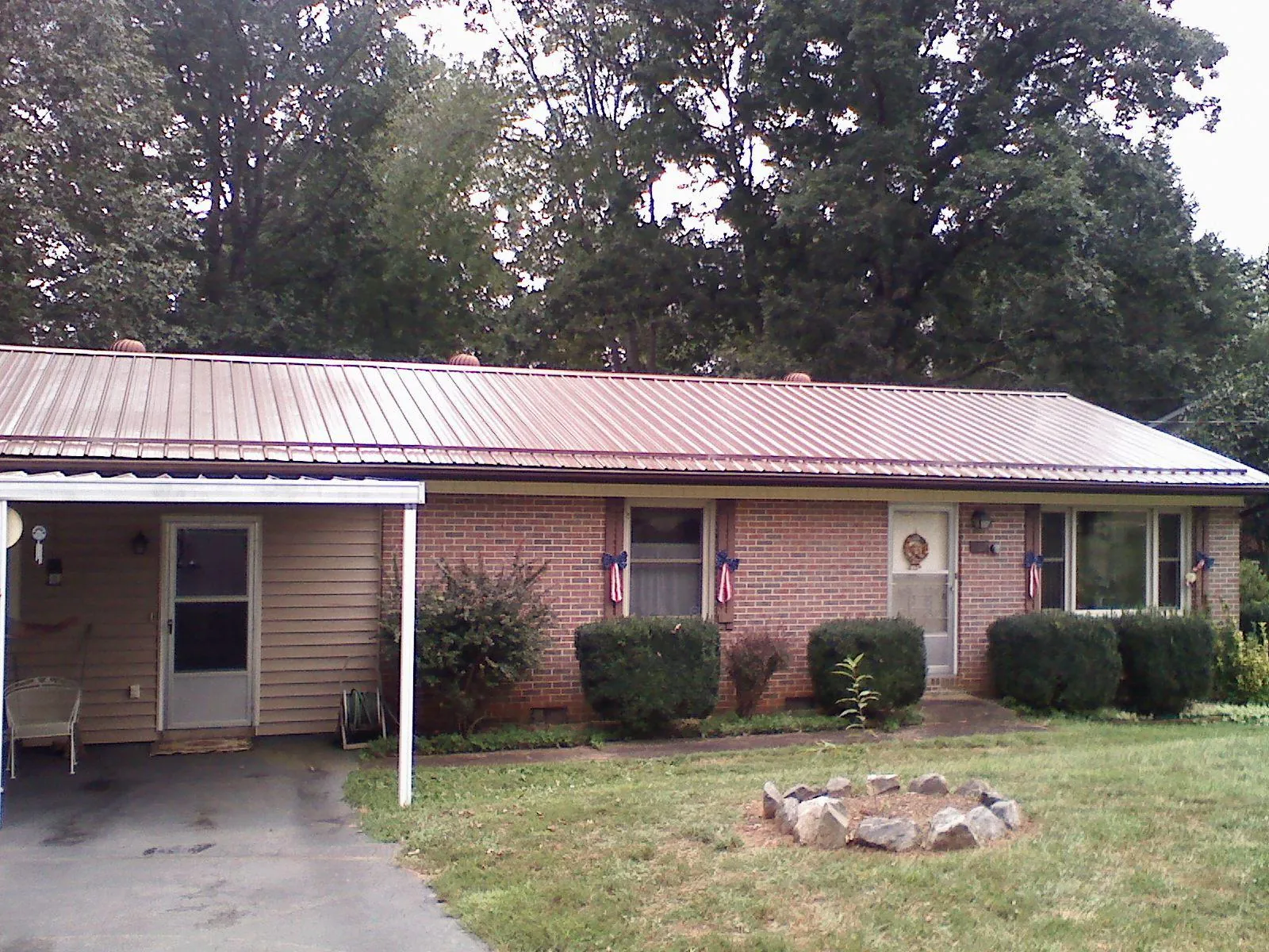 Bronze metal roof and carport on a brick ranch home — Roof Repair work by our crew in Ohiopyle